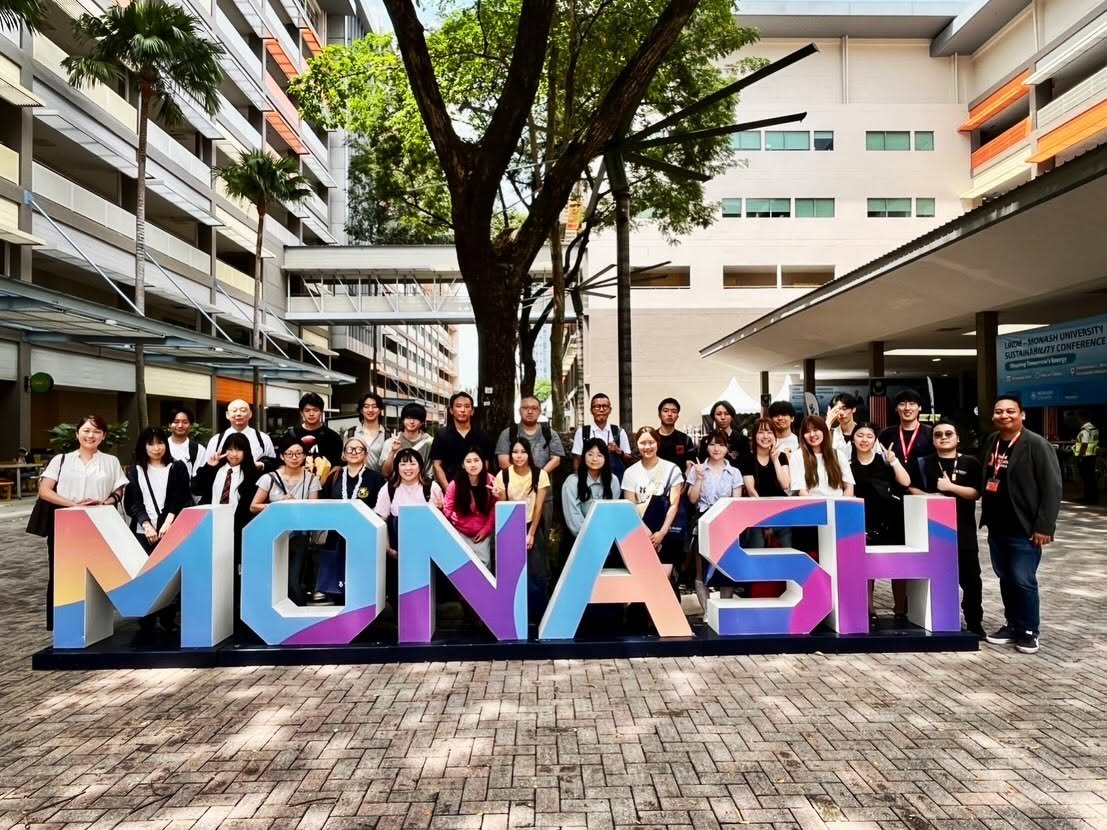 モナシュ大学マレーシア校の前で視察ツアー参加者と記念撮影